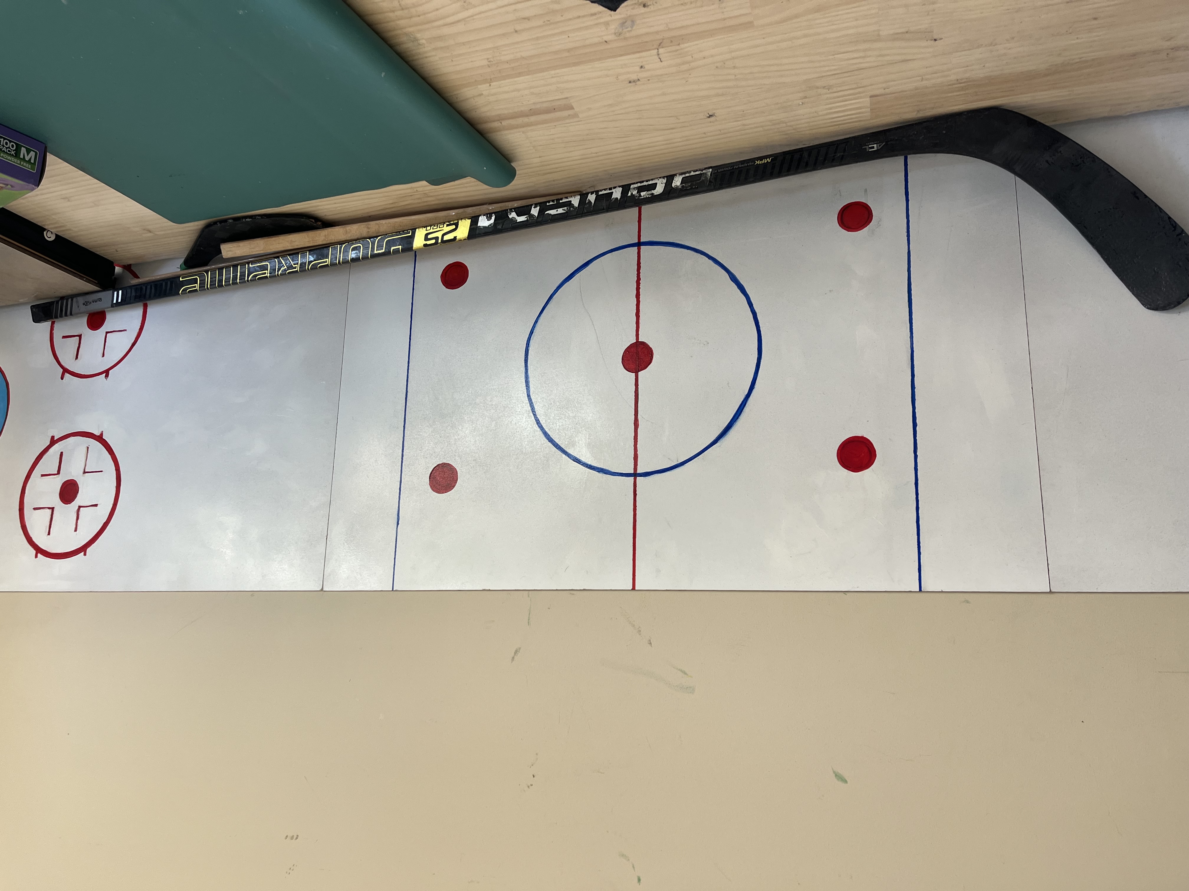 Repaired Bauer Supreme stick back in one piece against a mini rink wall