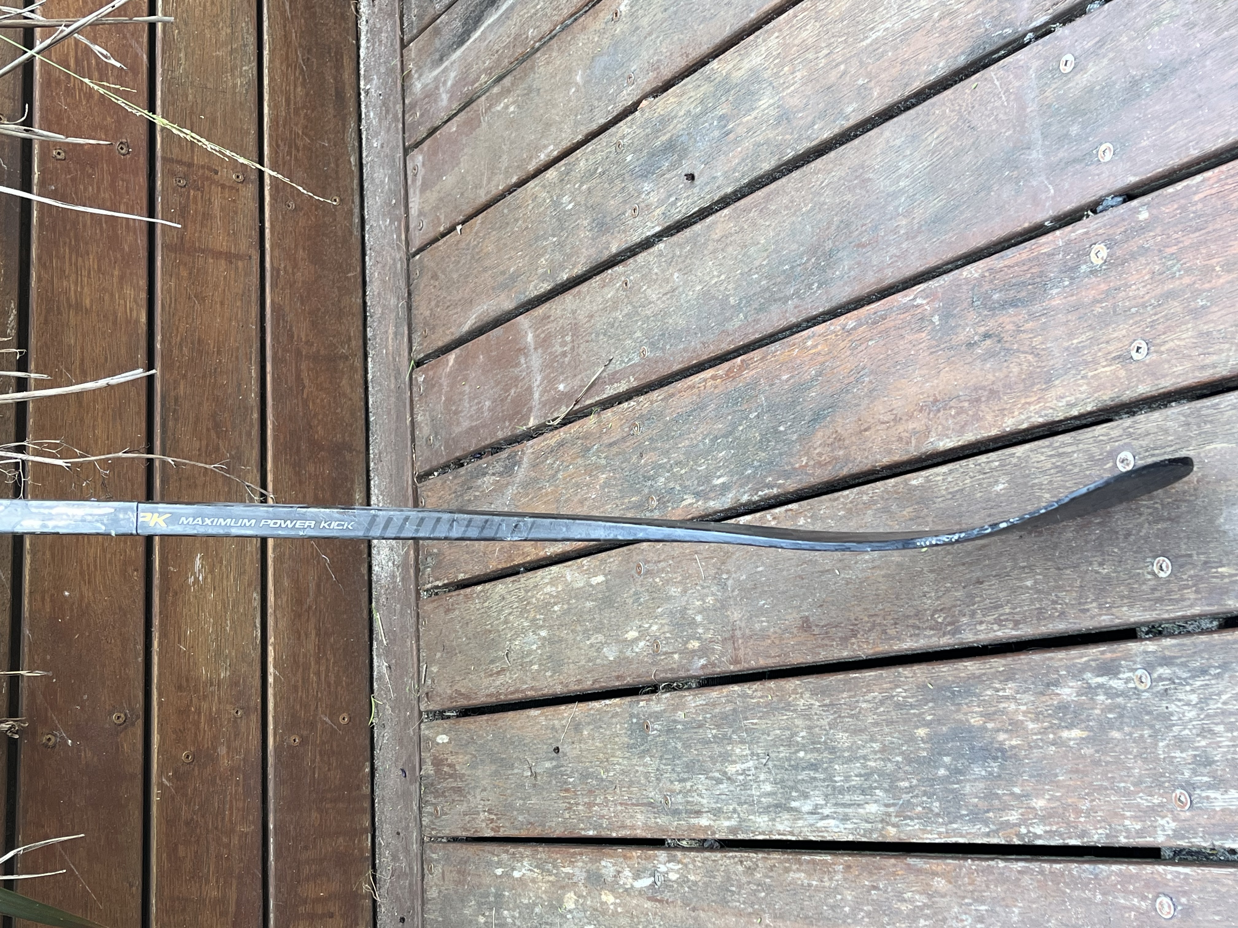 Repaired stick standing straight on a timber deck