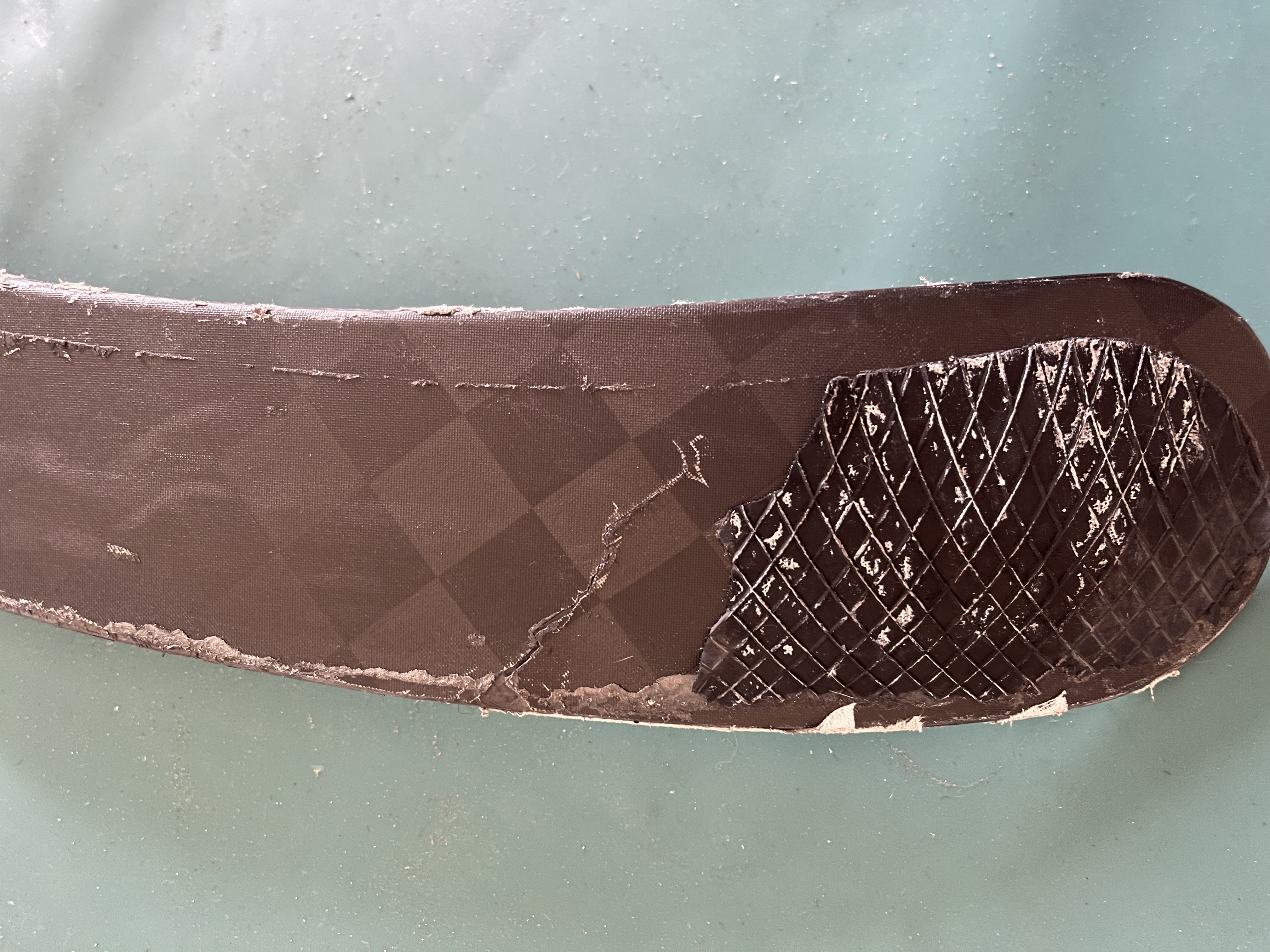 Worn backhand of the blade with cracks and fraying edges